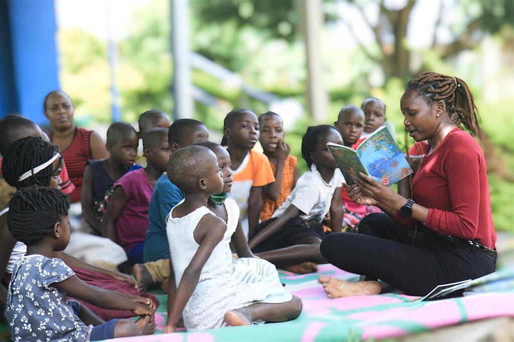A lady reading a book to other children